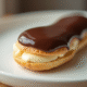 Éclair au chocolat frais sur assiette blanche