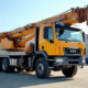 Camion grue d'occasion stationne en plein soleil dans un lot industriel